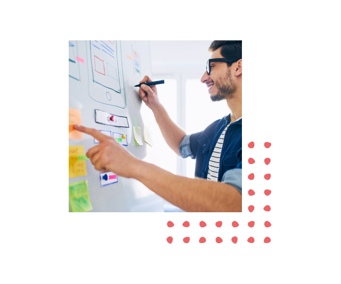 Man smiling while drawing an idea on a whiteboard