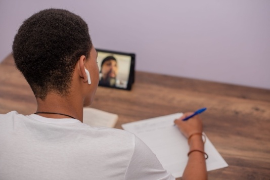 blog post header image of a young man participating remotely in an online class