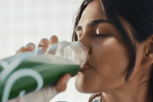 Athletic Greens image, woman drinking from bottle