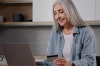 Older woman sitting at computer with credit or debit card