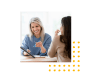 Image of a woman showing another woman something on a tablet