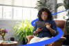 Woman sitting in chair while using a tablet surrounded by blue path