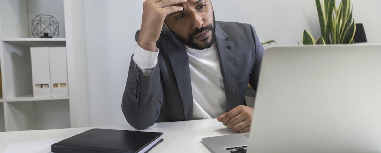Man looking at his laptop frustrated