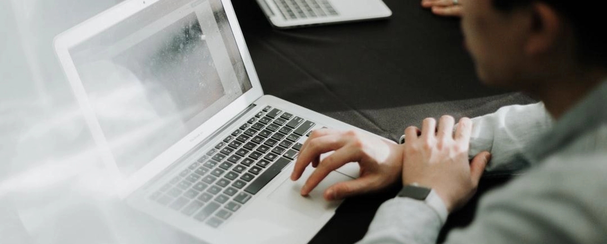 man sitting at a conference table working on his laptop