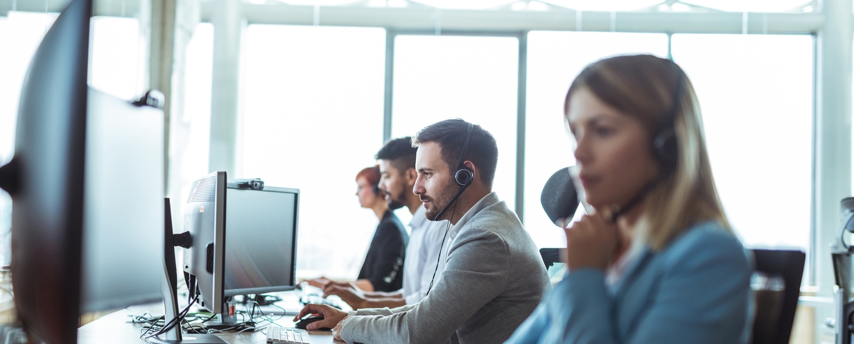 Photo of 4 call center workers answering customer support calls