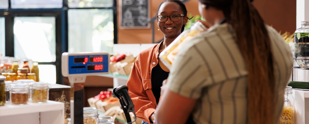 Woman buying organic produce at a store check out. 