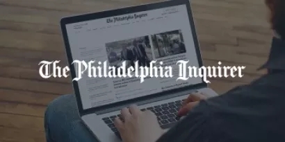 Person using laptop with overlay "The Philadelphia Inquirer"
