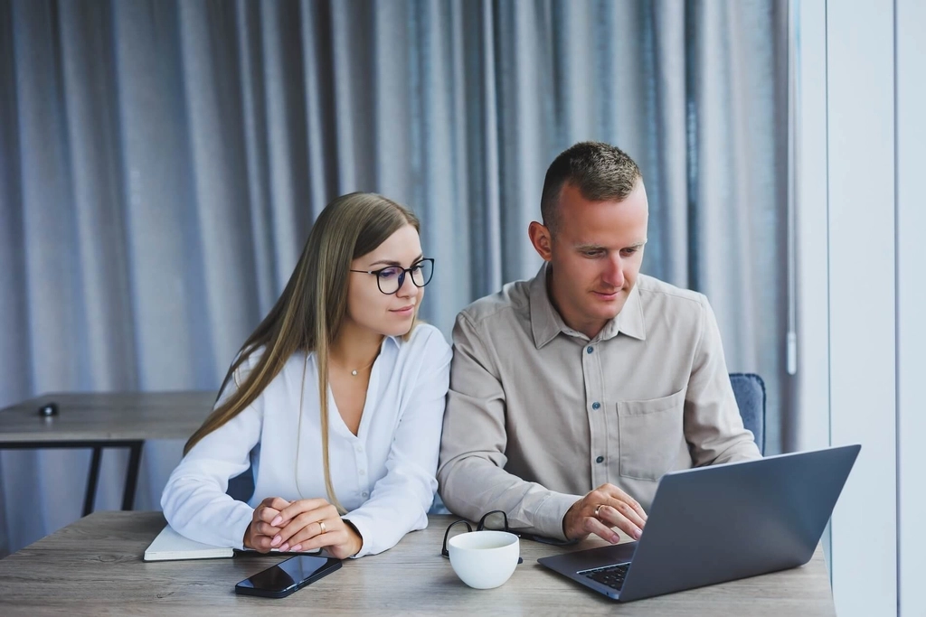 Business professionals discussing user feedback in front of a laptop
