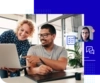 Photo of two professionals smiling at a laptop with a smaller image of a video player showing someone talking