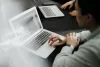 man sitting at a conference table working on his laptop
