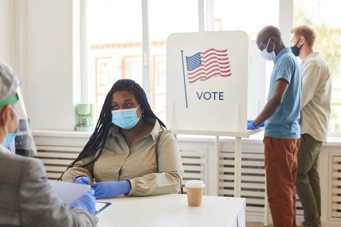 Image of people by a vote sign