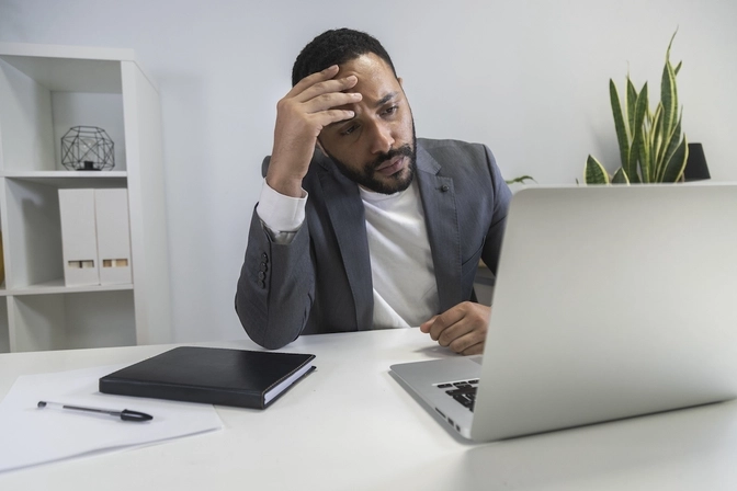 Man looking at his laptop frustrated