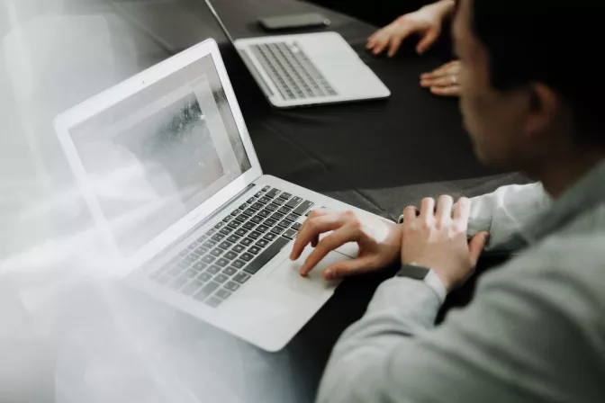 man sitting at a conference table working on his laptop