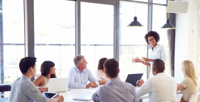 Photo of a group of business people seated in a meeting room for a presentation